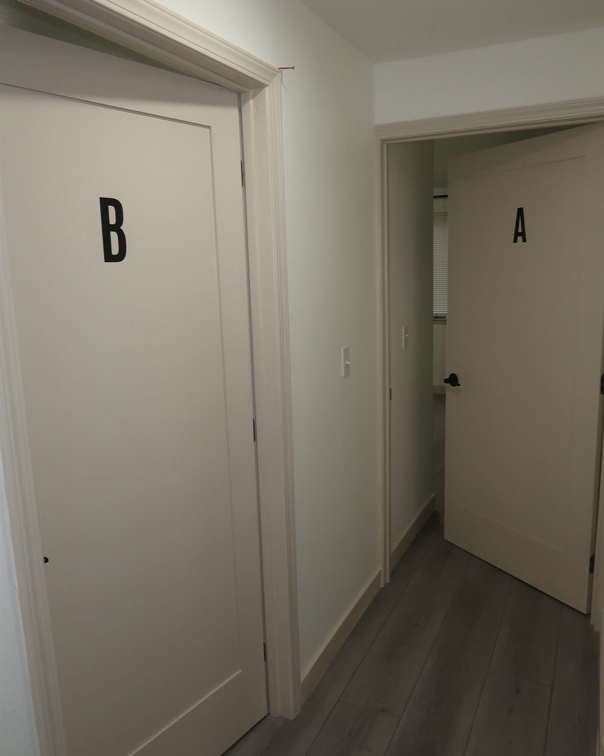 The hallway at Alder House of Comfort, with lettered doors to two private rooms